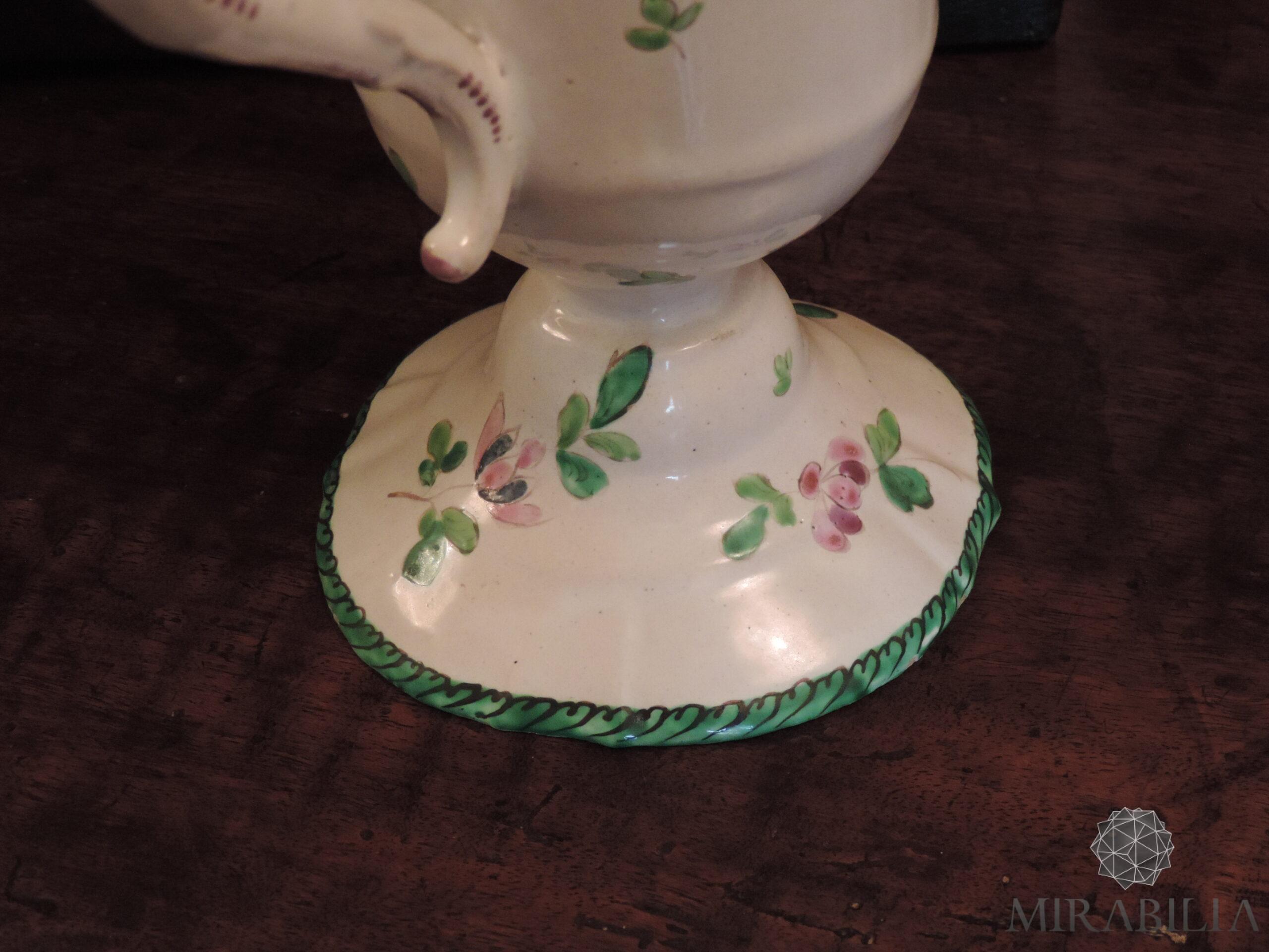 Versatoio realizzato in maiolica in policromia a piccolo fuoco con verde, giallo, rosa lilla, blu, opera del ceramista Pasquale Rubati (dettaglio base) Versatoio realizzato in maiolica in policromia a piccolo fuoco con verde, giallo, rosa lilla, blu, opera del ceramista Pasquale Rubati (dettaglio base)